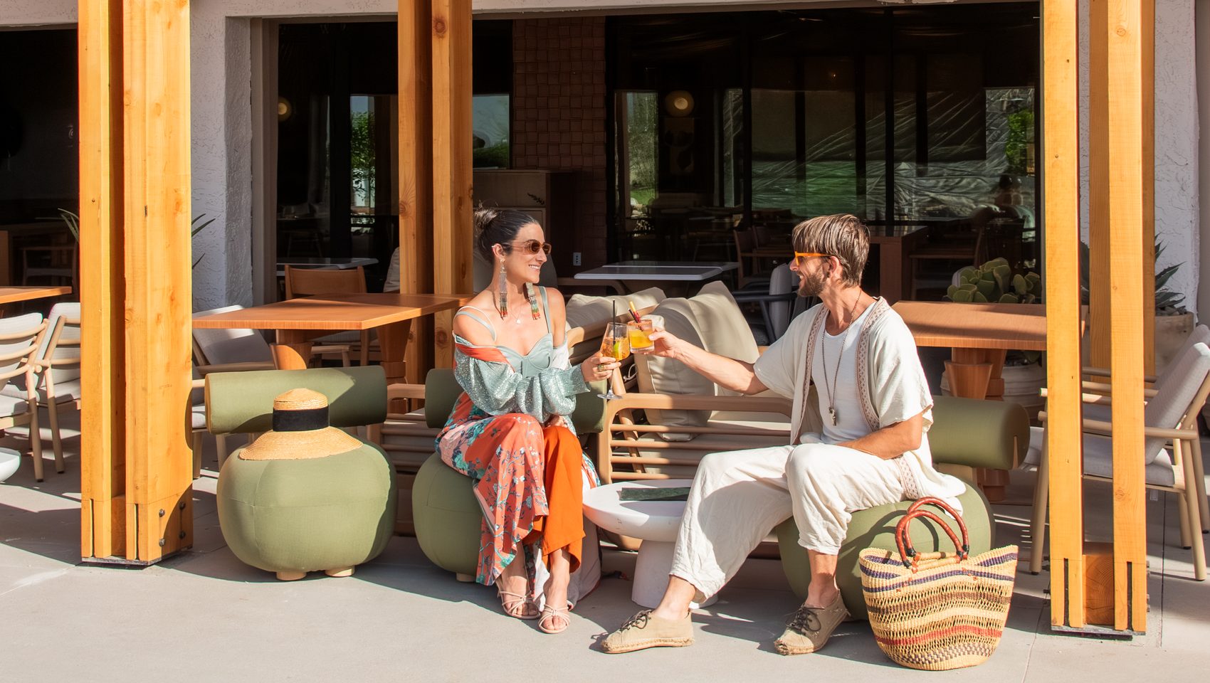 a couple toasts their cocktails at Kimpton Miralina