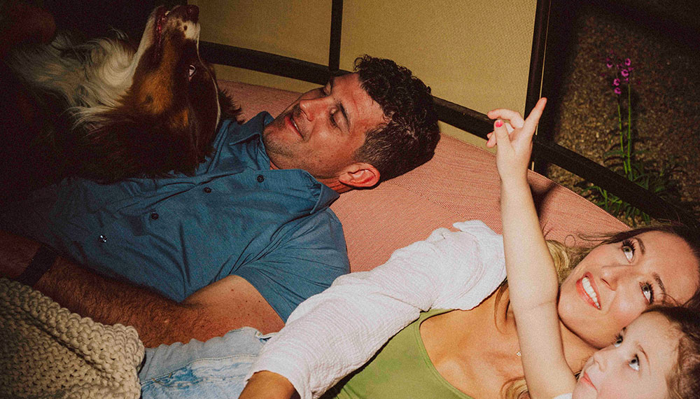 A family lays outside looking at the stars at Kimpton Miralina