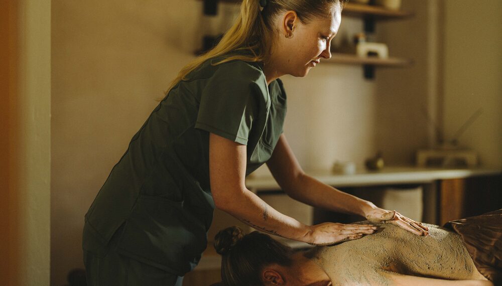 Guest receiving mud massage at Kimpton Miralina