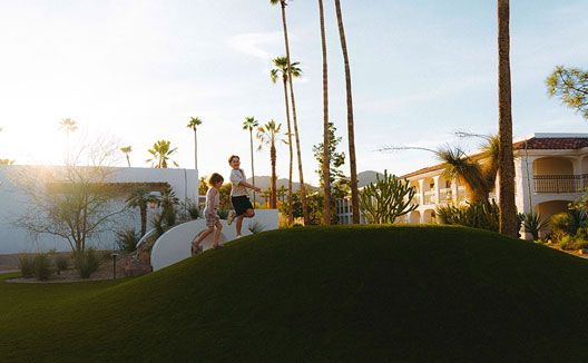 rolling grass hill with kids running on it at Kimpton Miralina