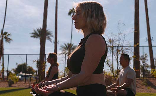 Woman in yoga pose outside at Kimpton