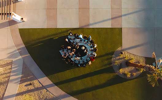 People at an outdoor circular table at Kimpton miralina
