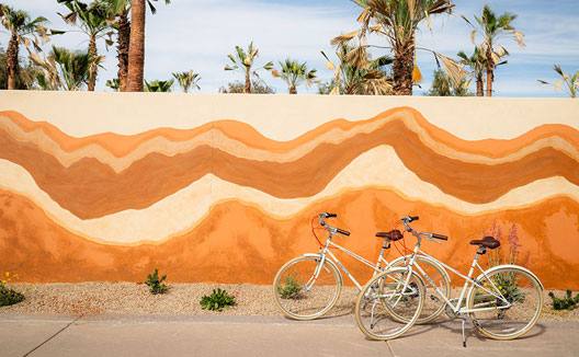 A painted outdoor art wall at Kimpton Miralina with bicycles near it